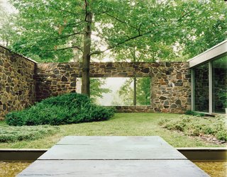 Marcel Breuer Hooper House II - Photo 2 of 9 - A large rectangular cut in the back wall of the house creates views from the entrance through a courtyard to the trees and lake beyond.