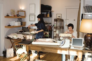 In her sunny studio, Joanna Notkin (left) assembles pillows while Anna Borstand, who manages sampling and production, carefully threads a needle.