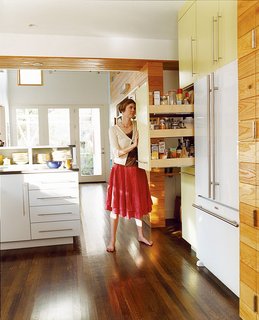 Double Time - Photo 4 of 7 - The kitchen links the new and old parts of the house; fittingly, its style is somewhere between traditional and modern. A kitchen wall makes room for a fridge and roll-out shelving.