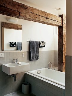 Rather than concealing the barn frame in the private rooms, Cohen created an interplay between modern and historic elements in the master bathroom.