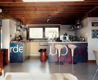 Carver and Carloss's choice of kitchen design by artist friend Neil Jolliffe reflects the couple's eclecticism and playfulness. The kitchen cabinetry draws from the soft pastel shades often seen in English coastal towns. The lighting fixtures are Giant Pendants from Original BTC.