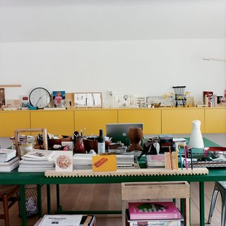 Behind Nina Tolstrup’s dining table/office desk is a sideboard she designed herself, which is littered with things she has both collected and made.