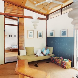An Inno-native Approach - Photo 4 of 9 - Sara Asafu-Adjaye rests on a couch in the TV room. The IKEA light fixture and other imports give the house its blend of Western and African, mass-produced and handmade.