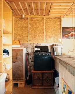 No Grid in Sight - Photo 6 of 8 - Kitchen and living room walls were constructed of clear and white acrylic panels stuffed with straw to allow for natural ventilation and light to filter softly into the house. The walls leaked after the first winter and the straw sank down in the frames. Students returned to the site, sealed and filled the walls with Styrofoam (leaving the straw-fill in the kitchen as is).