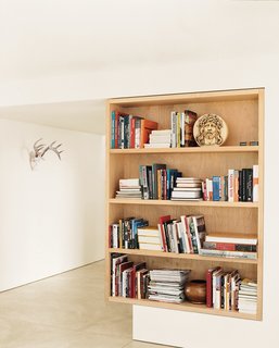 A maple bookcase defines the point between the living room and foyer.