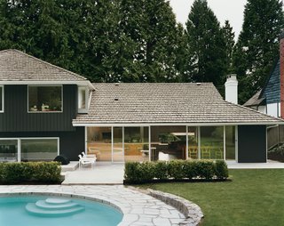 After trying dozens of colors, LeBlanc says, they settled on basic black for the exterior as <br><br>a way to best marry the building with its forest surroundings, which include 30-foot-high western red cedar trees. The pool is original; but the deck, once made of concrete, has been reclad in granite to match the old retaining wall.