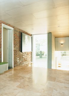 An area that once led from the original house to the garage is now enclosed and serves as a transitional space between the private and public areas of the house.