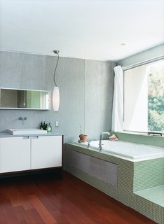 The master bathroom, outfitted with Bisazza tiling, has a view of the backyard from the tub.