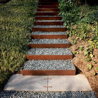 The stairs going up the knoll to the roof garden and to the house’s second-level entrance are made from Cor-Ten steel risers (which develop a rich, rusted patina) and filled with gravel in order to create a nonslip surface that drains well. Steel and steelwork by Virginia Industrial.