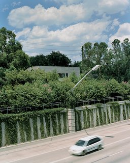 The house is sheltered from the speeding traffic on Highway 59 by a fortress of trees.