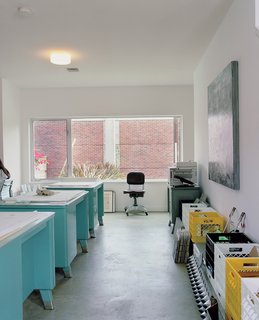 The office windows look onto the brick wall that buffers the property from the highway beyond.