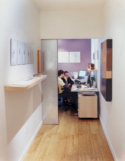 The view into the onetime master bedroom, now an office for six, from the hallway.