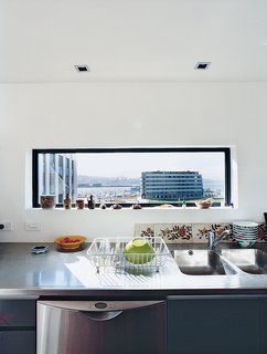 Over the Bieringas’ kitchen sink, a sliver of a window provides a peek at the newly created Waitangi Park on the revitalized Wellington Harbor.
