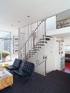 A floating steel staircase ties the living area and loft together. Variegated steel tubes provide graphic punch while maintaining the apartment’s airy and open feeling.