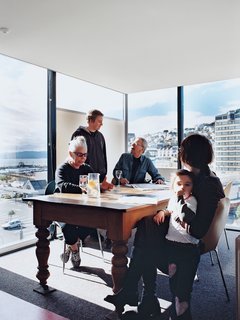 Jan Bieringa (seated, left) hangs out with her son, Kris Bieringa (standing), Tony Hiles, Judith Fyfe, and Fyfe’s granddaughter, Phoebe Pottinger. Surrounded on three sides by glass walls, the dining room is the perfect spot to soak up the stunning views <br><br>of Wellington Harbor and the hilly eastern suburbs.