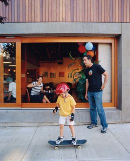 Community Building - Photo 8 of 10 - Resident Brooks Jordan and his son Leif take some time out to play outside the Belmont, where a steady stream of pedestrians and diners lend the building an inviting feel.