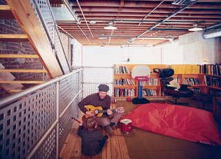 In the family room, Lucien gets an early start on his music career with his father’s help. The space, technically the third floor of the structure, overlooks the central living area below.