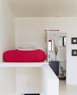 The bed is perched above the staircase leading from the second-story living area to <br><br>the third-story sleeping area.