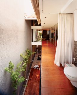 Because the house is narrow and long (16 by 68 feet), the design team decided to create a huge open-air space to light the interior naturally. Two retractable motor-driven <br><br>canvas canopies shelter the space during Singapore’s frequent rains.