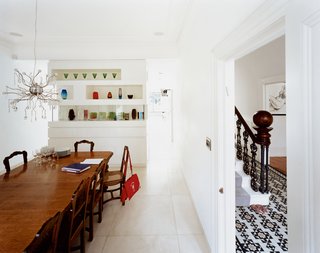 "I like the idea of houses having layers," says Phillips, who incorporated the home’s strong traditional features into his design. He kept the formal dining room, for example, which is divided from the kitchen by an elegant cabinet displaying colorful glass vases, but also created a more casual dining environment in the new extension.