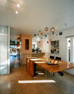 Solar Inspiration - Photo 3 of 8 - In the dining/kitchen area there are cabinets and floors made of oriented strand board (OSB) and a cherry dining table fabricated by Joe Cooper to the architects’ design.
