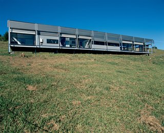The front facade nestles into its hillside site.