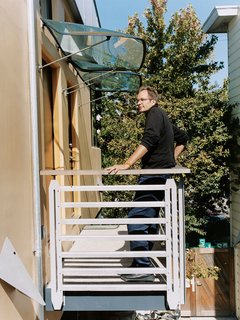 The multitalented Wanaselja admires his handiwork from a second-story landing on the phase-two units. More car hatches create distinct awnings.