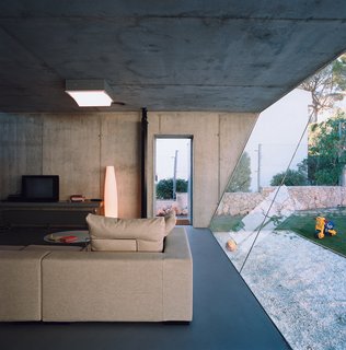 Suburban House of the Future by Cloud9 - Photo 5 of 10 - On the living room ceiling a Sivra fixture by iGuzzini modulates its output based on the amount of available daylight. The sofa is Wall by Piero Lissoni for Living Divani.