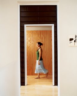 Hardwood floors throughout provide continuity from the living space to the sleeping quarters. The entryway staircase divides the two structures.