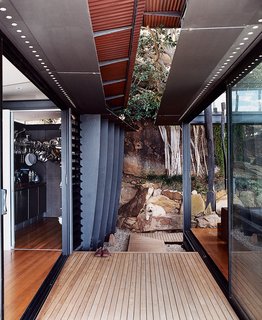 Three Glass-and-Copper Pavilions Conquer the Cliffs - Photo 7 of 10 - The family dog enjoys the shade provided by the corrugated-copper roof overhangs.