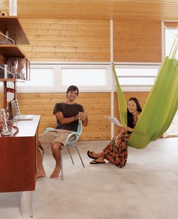 A vintage suspended wall unit serves as a home office. Cathy demonstrates the "third bedroom"—a three-person hammock from Oaxaca.