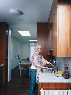 Although there are no doors to truncate the space, the kitchen and guest room close off with translucent fabric panels that filter natural light by day and glow like lanterns at night.
