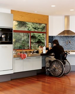 The Siple Life - Photo 5 of 9 - Meal prep is simplified for Siple. All the cabinets are easy to open, there’s space under the cooktop for his wheelchair, and a faucet over the range removes the need to haul pots to the sink for filling.