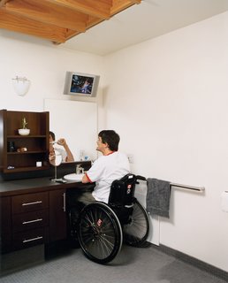 The Siple Life - Photo 8 of 9 - In the master bath, a different kind of view is afforded by a wall-mounted TV that can be seen from almost everywhere in the room—ensuring that Siple doesn’t have to miss even a minute of his beloved hockey games.