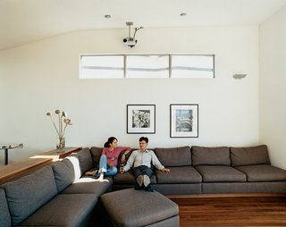 The theme of casual living is reinforced with plush, oversize couches designed by the architect. Like the versatile workstation, they play multiple roles by incorporating beautiful walnut shelving into their construction.