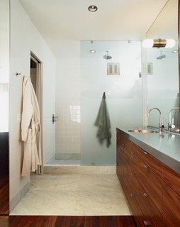 The unifying elements of walnut and steel—with a little marble and concrete thrown in—continue downstairs in the bathroom and bedroom.