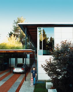 Turning its back to the street and next-door apartment like a curled-up cat, the long, narrow house spills out sideways to the garden, designed by landscape architect Andrea Cochran.