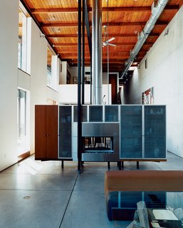 David Baker and cabinetmaker Thomas Jameson designed the freestanding fireplace / media console, which effectively divides the more formal living room from the dining and gathering space while concealing cords and other clutter.