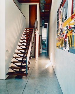 The house moves in linear fashion towards increasingly private zones—upstairs to the family room and down the hall to the master bedroom, where an open door reveals a secluded garden room at the very back.