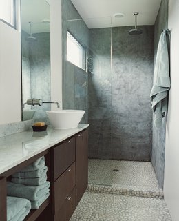 Houston, We've Solved a Problem - Photo 6 of 8 - Naturally subtle tones predominate in the bathroom, with Walker Zanger stone floors complemented by sanded concrete walls and dark mahogany cabinets topped by a slab of white marble. 