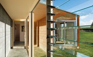 The long corridor between the guest and main quarters provides ample light and lovely views in addition to acting as one of the Longhouse's most hard-working green elements. The concrete Trombe wall collects sunlight and distributes it as heat throughout the home.