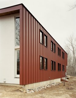 Gaffney House Dining Room - Photo 9 of 10 - To avoid constant maintenance issues—after all, "durability is part of sustainability," Gaffney states—the roof is clad in standing seam metal and the siding is composite plastic decking, rather than easily weathered wood.