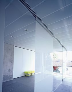 The movable glass partitions in the second floor of the office space provide privacy and translucent natural light (the space also serves as a guest room).