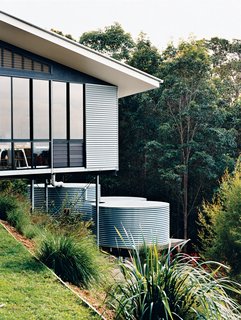 The studio is clad in corrugated tin, echoing the adjacent water-storage tanks, which collect and filter rainwater off the roof.