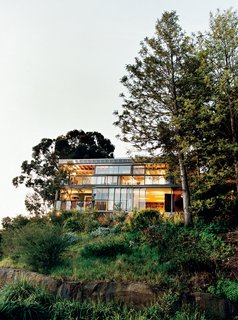 The rear facade. A system of sliding glass windows and doors underscore the indoor/outdoor nature of the house.