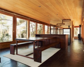 Barerock’s minimal interior is augmented by a built-in dining area made from African padauk, a decay-resistant hardwood. The mirrored kitchen wall echoes the exterior’s distinguishing feature.