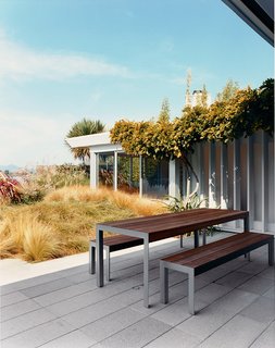 The large expanse of windows that now surround the house feature remote-operated awning and roll shades by Mechoshade and Eastern Awning.