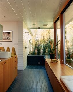 In the master bathroom, all boundaries between inside and outside and public and private are virtually eliminated. The dark tiles are by Ann Sacks.