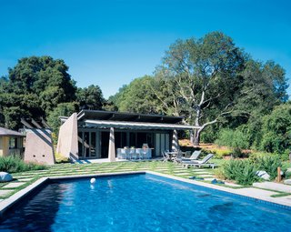 Colored concrete walls, pivoting glass doors, and a scissor-shaped steel roof maintain the fun and modern feel of this computer-game designer’s suburban poolside shelter.<br><br>Project: Traeger Pool House<br><br>Architect: Dan Phipps Architects<br><br>Location: Woodside, California
