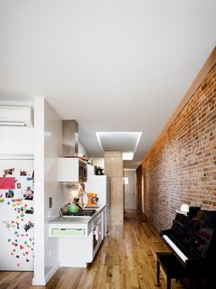 Storage-Smart Renovation in New York City - Photo 6 of 14 - From the living room, the narrow apartment stretches back into the sleeping quarters by way of a compact kitchen that packs all the needs of a home chef against one wall.